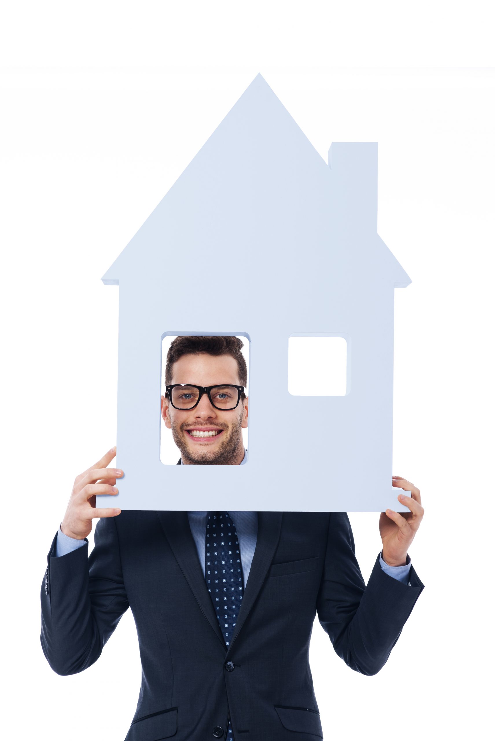 smiling businessman holding house sign scaled