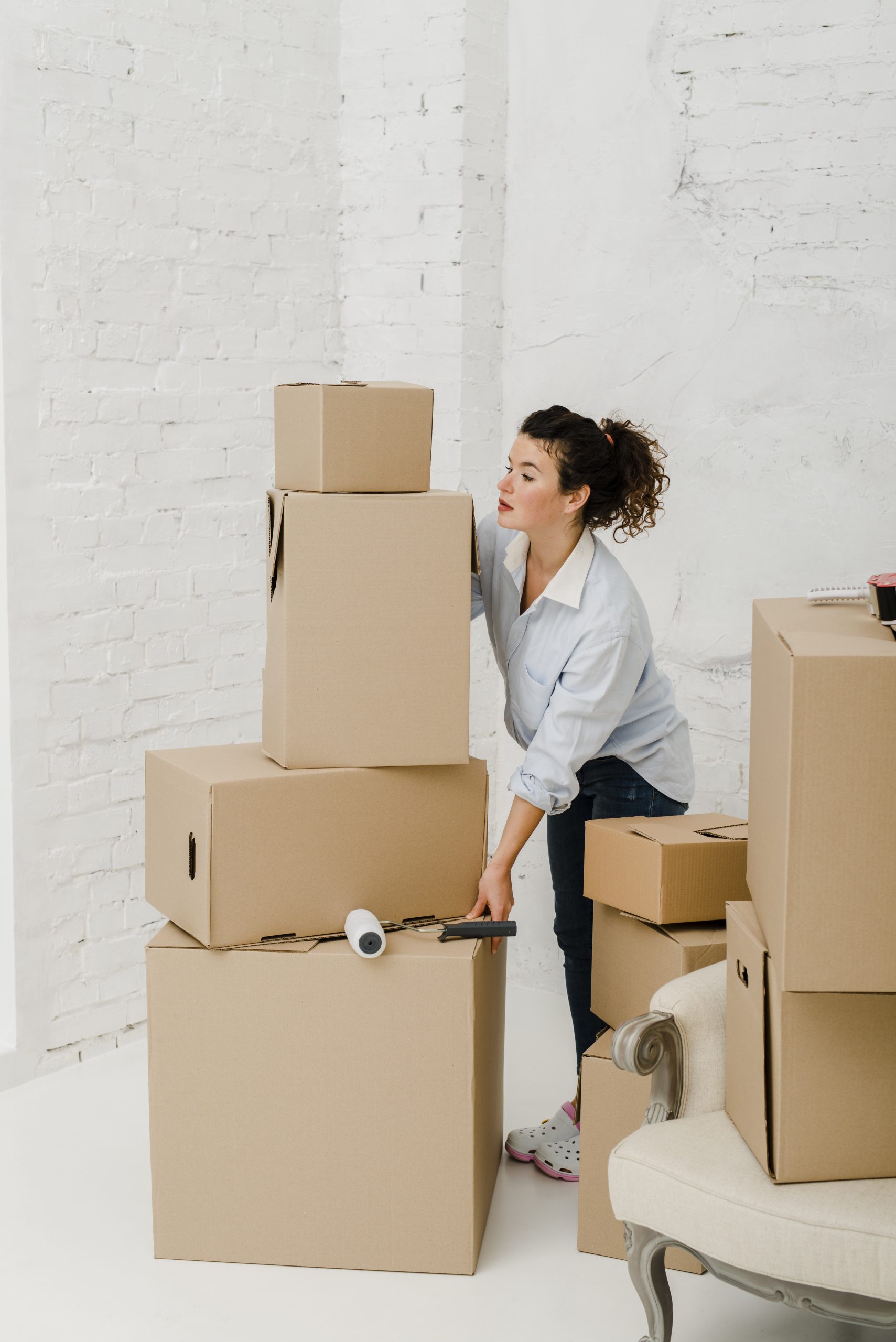 woman moving stack boxes scaled